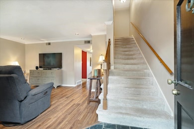 Staircase featuring hardwood / wood-style flooring and ornamental molding