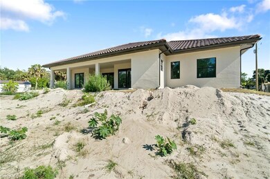 Rear view of property featuring a tiled roof and stucco siding