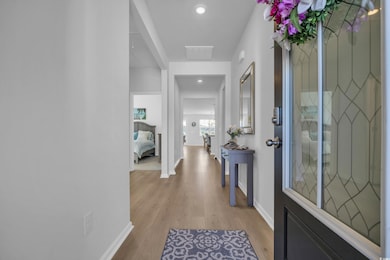 Hall featuring baseboards, recessed lighting, and 