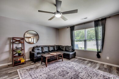 Living area featuring wood finished floors and a ceiling fan