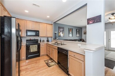 Open Kitchen With Wood Floors And Maple Cabinets