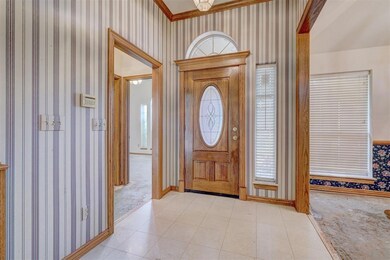 Tiled entrance foyer featuring crown molding