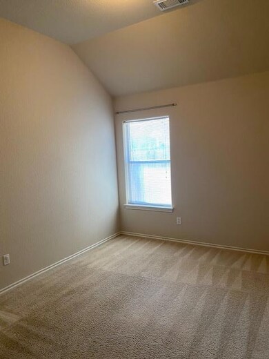 Empty room with carpet floors and vaulted ceiling