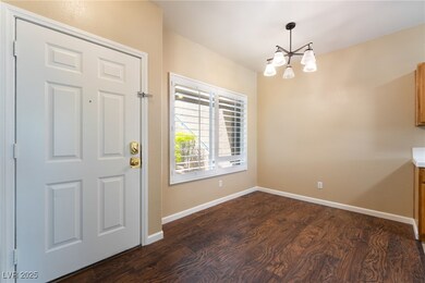 Foyer featuring dark wood finished floors, a chand