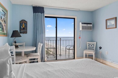 Bedroom with a water view, an AC wall unit, access to exterior, and a textured ceiling