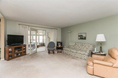 Spacious living room with French doors to sunroom.