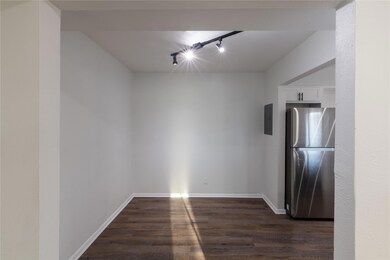 Empty room with baseboards, track lighting, electr