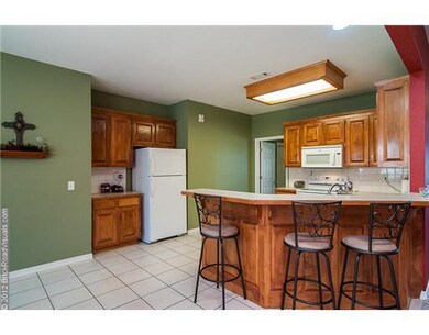 Kitchen. Kitchen has lots of floor space, custom cabinets and tile floor. Extra seating at the bar also!