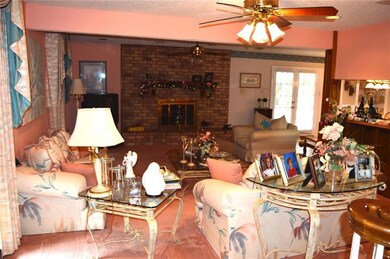 23 x 15.5 Den with wood-burning brick fireplace, kitchen and breakfast area are to the right.