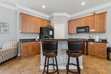 Kitchen featuring black appliances, a breakfast b