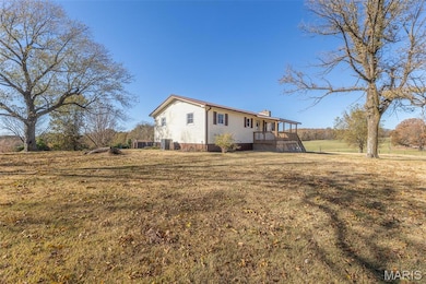 Back of property featuring a chimney and a yard