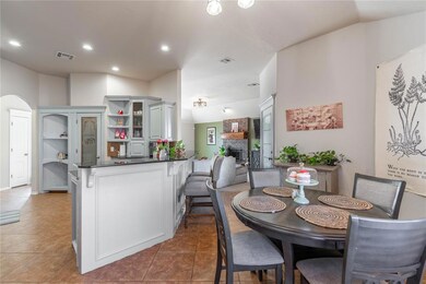 Tiled dining space featuring brick wall, a firepla