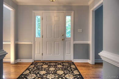 Welcoming foyer with hardwood floors, moulding, an