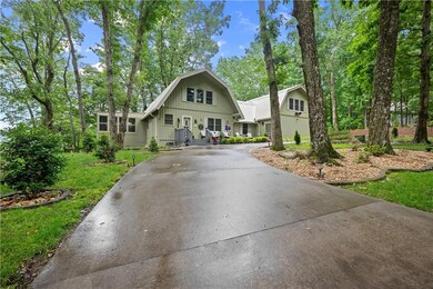 Dutch colonial with a gambrel roof, curved driveway, and board and batten siding