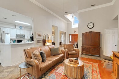 Living room with ornamental molding and a towering