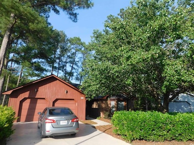 View of front facade with driveway and an outbuilding