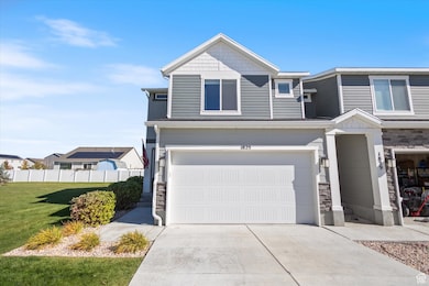 View of front of house featuring stone siding, driveway, and an attached garage
