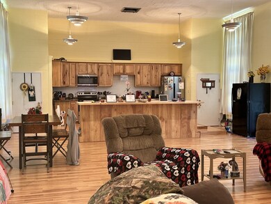 Living area with light wood-style floors and a high ceiling