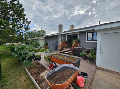 Back of property featuring a patio area, a garden, and a chimney