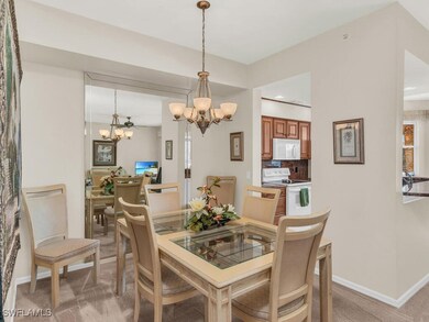 Dining area with a chandelier, light carpet, baseb