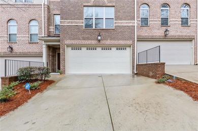 View of property featuring concrete driveway, bric