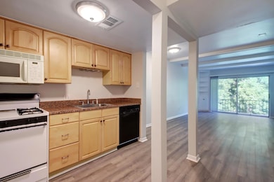 Kitchen featuring white appliances, light brown c