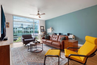 Living area with a ceiling fan, a wall of windows