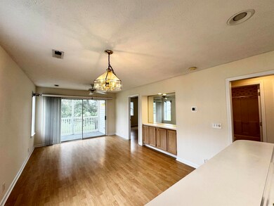 Unfurnished dining area featuring a chandelier, wood finished floors, baseboards, and a textured ceiling