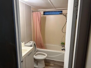 Bathroom with wood finished floors, shower / tub combo, and vanity