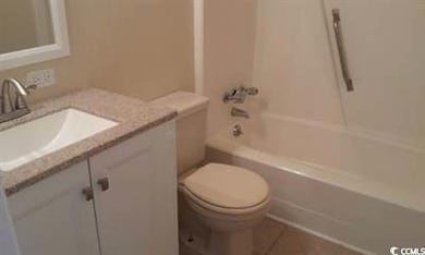 Bathroom with toilet, vanity, and washtub / shower combination