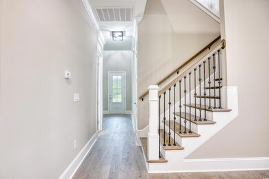 Foyer with ornamental molding and hardwood / wood-