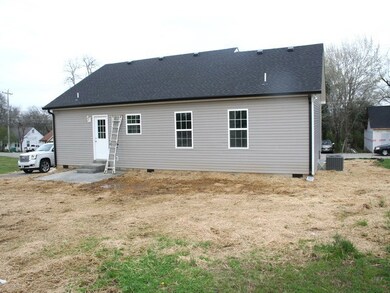 Black roof, grey painted outside, black gutters, and patio