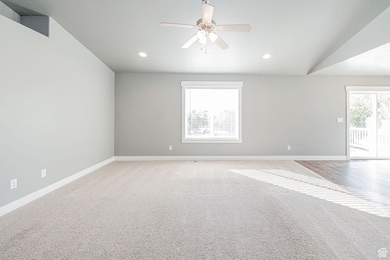 Unfurnished living room with carpet, a ceiling fan, recessed lighting, and vaulted ceiling