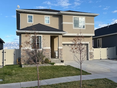 Traditional home featuring a gate, stucco siding, and driveway