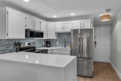 Kitchen features quartz countertops, glass tile backsplash and new stainless steel appliances.