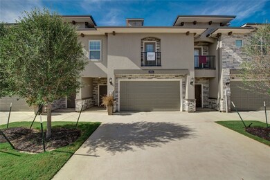View of front facade featuring stucco siding, a ba