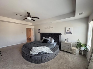 Bedroom with carpet flooring, a ceiling fan, and baseboards