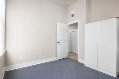 Unfurnished bedroom with visible vents, baseboard
