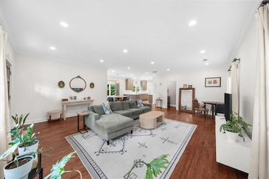 Living area featuring crown molding, dark wood finished floors, recessed lighting, and baseboards