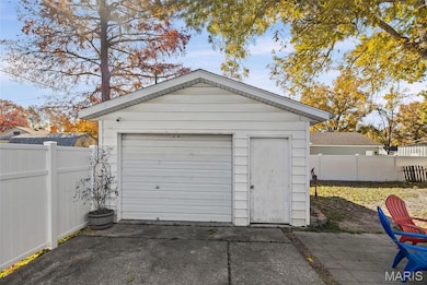 Spacious detached garage with electricity, workbench and a concrete driveway.