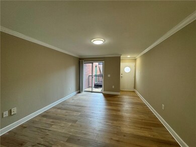 Spare room featuring baseboards, ornamental molding, and wood finished floors