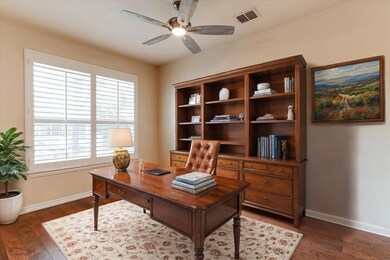 Office space with ceiling fan and dark hardwood / 