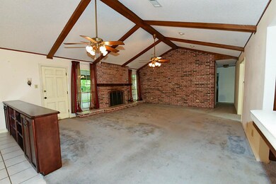 Living area with faulted ceiling and brick wall