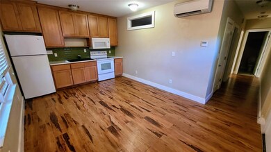 Kitchen with a wall mounted air conditioner, a si