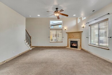 Unfurnished living room with a ceiling fan, a fireplace with flush hearth, light colored carpet, stairs, and recessed lighting
