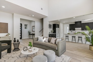 Living area featuring recessed lighting, light wood-style floors, and a towering ceiling