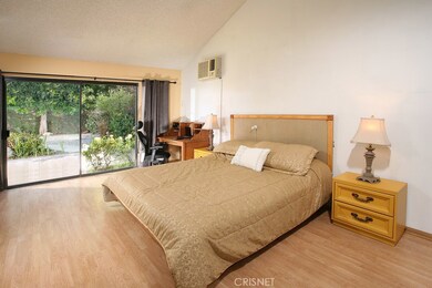 The expansive master suite offers vaulted ceilings, mirrored wardrobe doors, large walk-in closet, gleaming wood floors and private access to the backyard through the large patio doors.