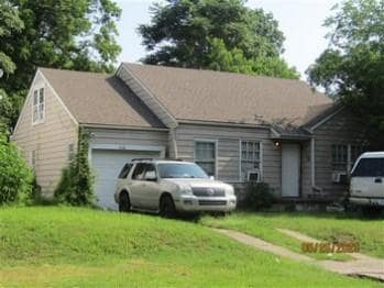 Ranch-style home with a front lawn and a garage