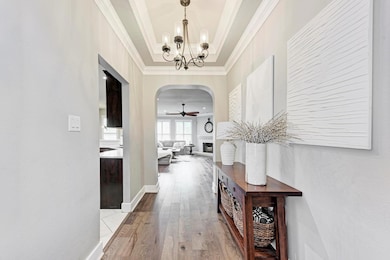 Hall featuring crown molding, arched walkways, wo