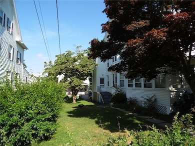 14 Spruce St, 3 family building. Side yard with view of single family in the back